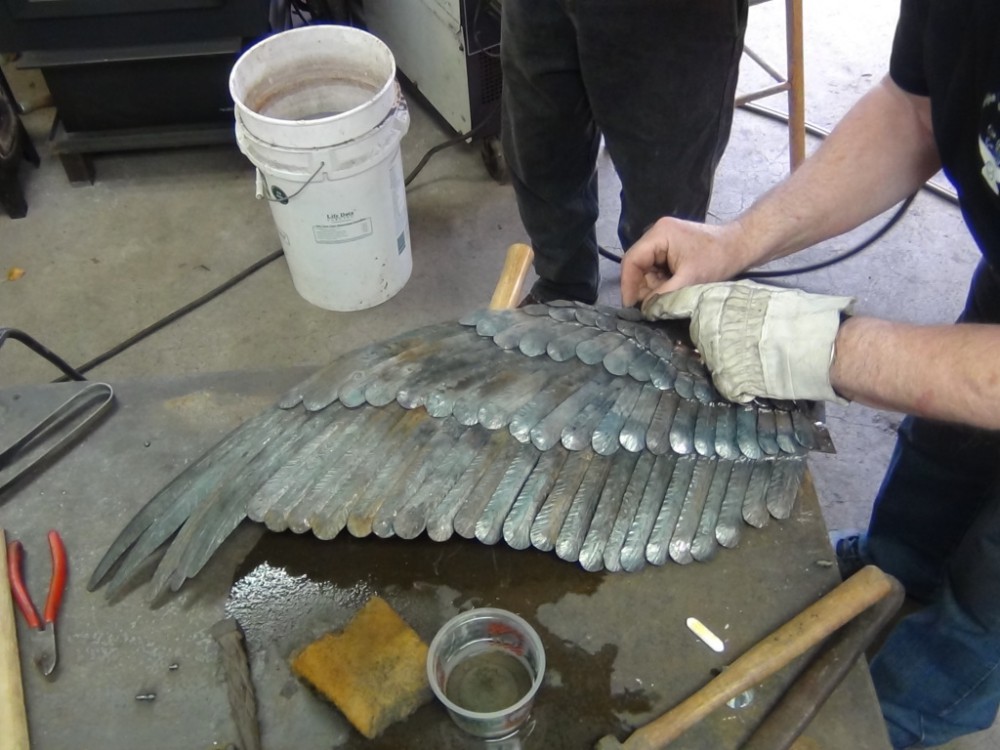De veren op de bovenste vleugel zijn bijna volledig. Nu moeten er nog veren onder geplaatst worden.