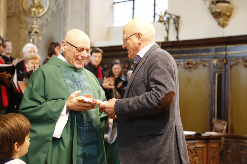 Wim De Vis overhandigt een cadeau aan Padre Renaat - het boek "Geloven in Gent"